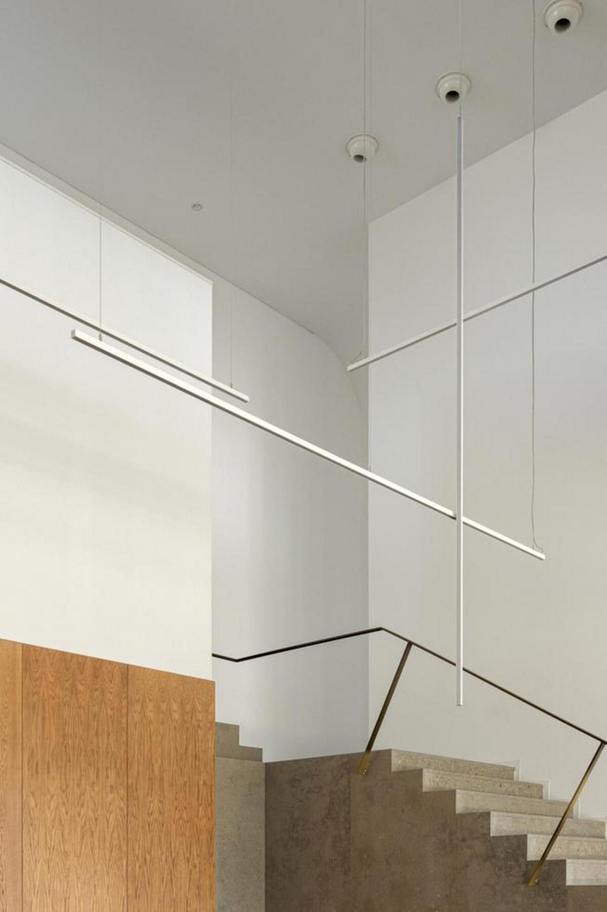 Escadaria monolítica em betão aparente, elemento estruturante que organiza a circulação vertical e a continuidade espacial no hall. — EDIFÍCIO-SEDE PRF arquitectura Impare Arquitectura fotografia Ivo Tavares