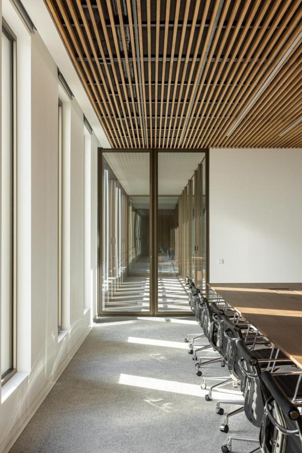 Detalhe dos postos de trabalho, com mobiliário moderno e cadeiras Catifa 46 da Arper, integrados num ambiente luminoso e funcional. — EDIFÍCIO-SEDE PRF arquitectura Impare Arquitectura fotografia Ivo Tavares