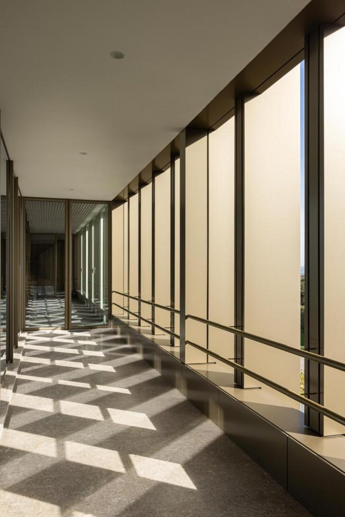 Vista noturna da fachada principal, com a iluminação interior a realçar os vãos envidraçados e a volumetria compacta do edifício. — EDIFÍCIO-SEDE PRF arquitectura Impare Arquitectura fotografia Ivo Tavares