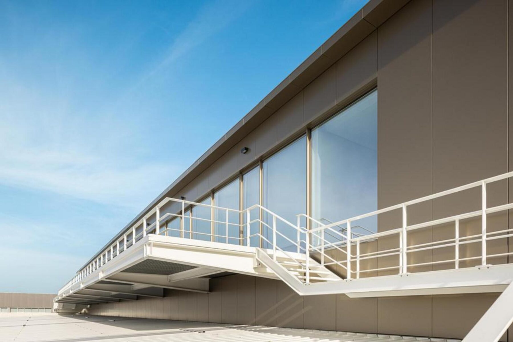 Perspetiva noturna do complexo, onde a luz artificial sublinha a continuidade espacial e a articulação entre os diferentes volumes. — EDIFÍCIO-SEDE PRF arquitectura Impare Arquitectura fotografia Ivo Tavares