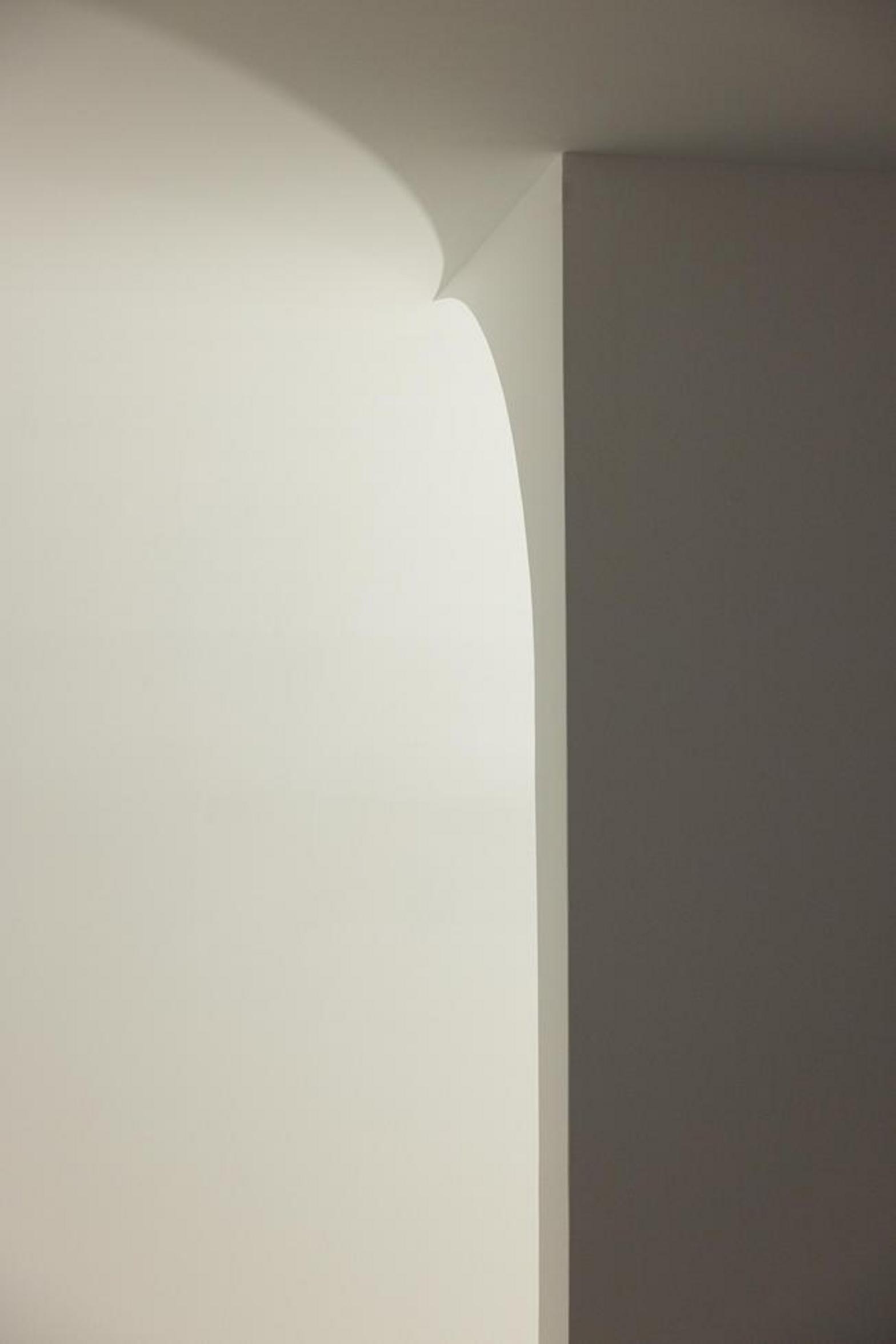 Detalhe de canto com parede curva e parede reta, criando uma transição suave e um jogo de luz e sombra — Novo Edifício-Sede PRF arquitectura Impare Arquitectura fotografia Ivo Tavares