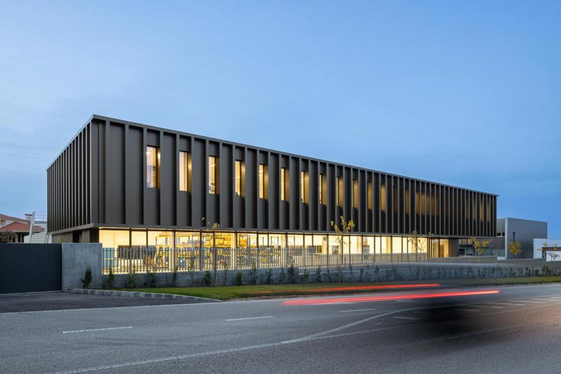 Vista noturna do open space administrativo, com a iluminação dos postos de trabalho a criar um ambiente produtivo e acolhedor. — EDIFÍCIO-SEDE PRF arquitectura Impare Arquitectura fotografia Ivo Tavares