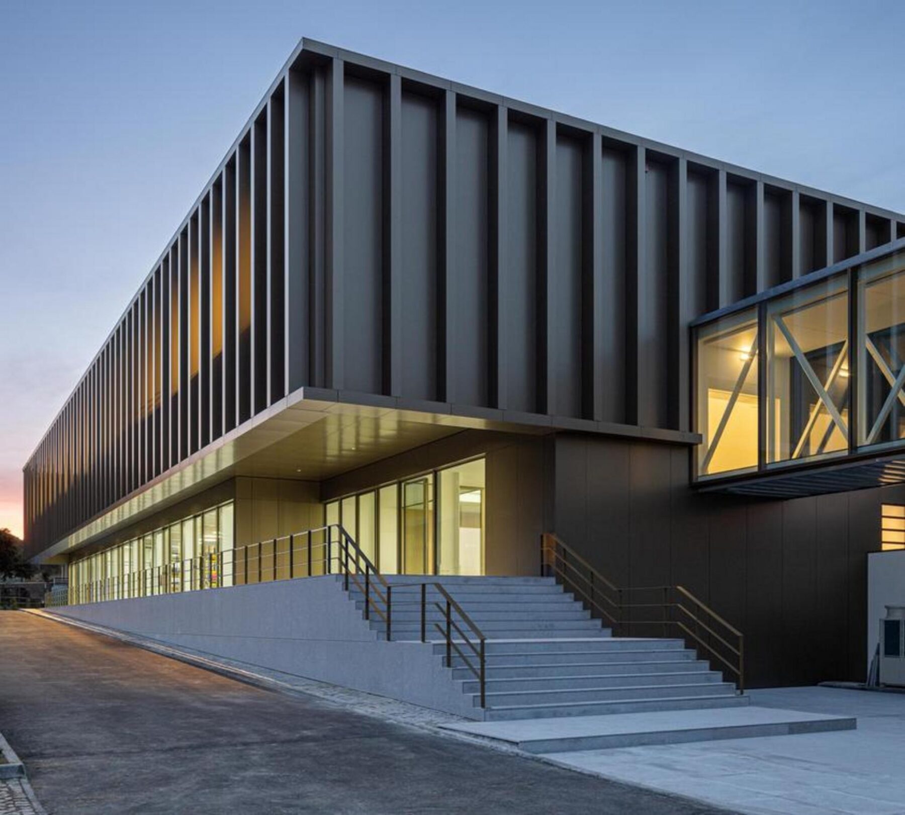 Plataforma elevada exterior, parte do percurso de ligação, que reforça a integração funcional e visual entre o novo e o antigo edifício. — EDIFÍCIO-SEDE PRF arquitectura Impare Arquitectura fotografia Ivo Tavares