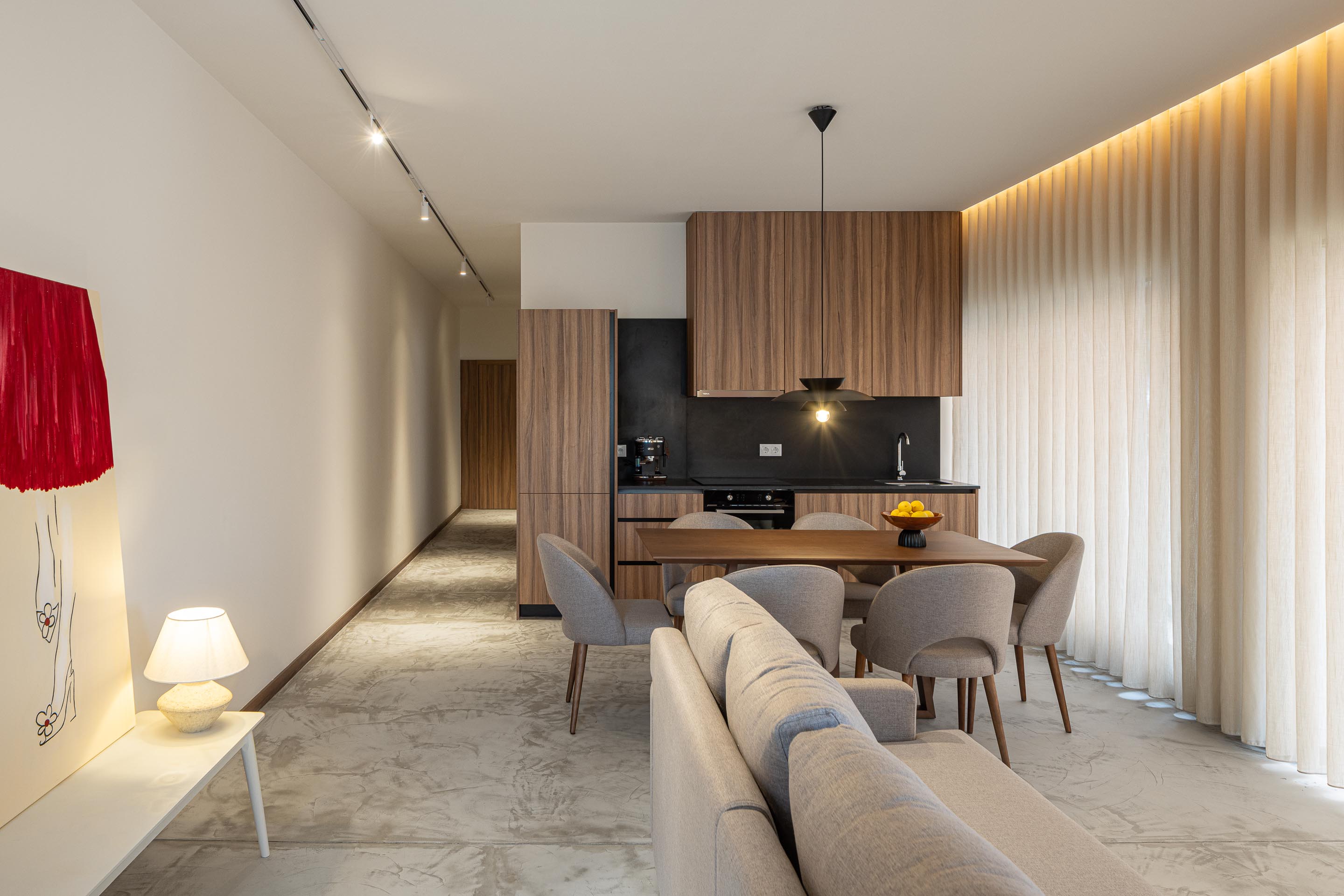Sala de estar e cozinha em plano aberto, com pavimento em betão e iluminação linear — Boutique Apartments arquitectura HPA fotografia Ivo Tavares