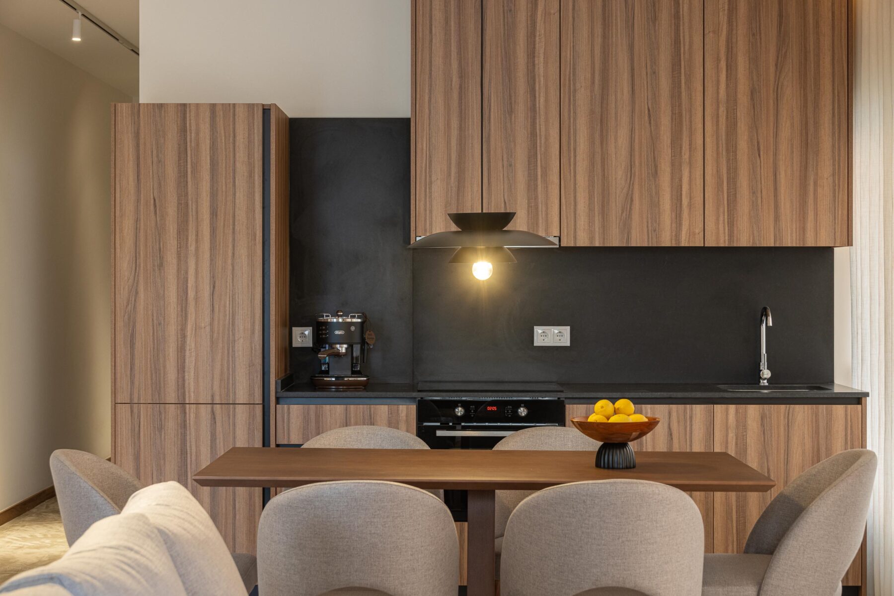 Detalhe da cozinha com armários em madeira, bancada preta e candeeiro suspenso — Boutique Apartments arquitectura HPA fotografia Ivo Tavares
