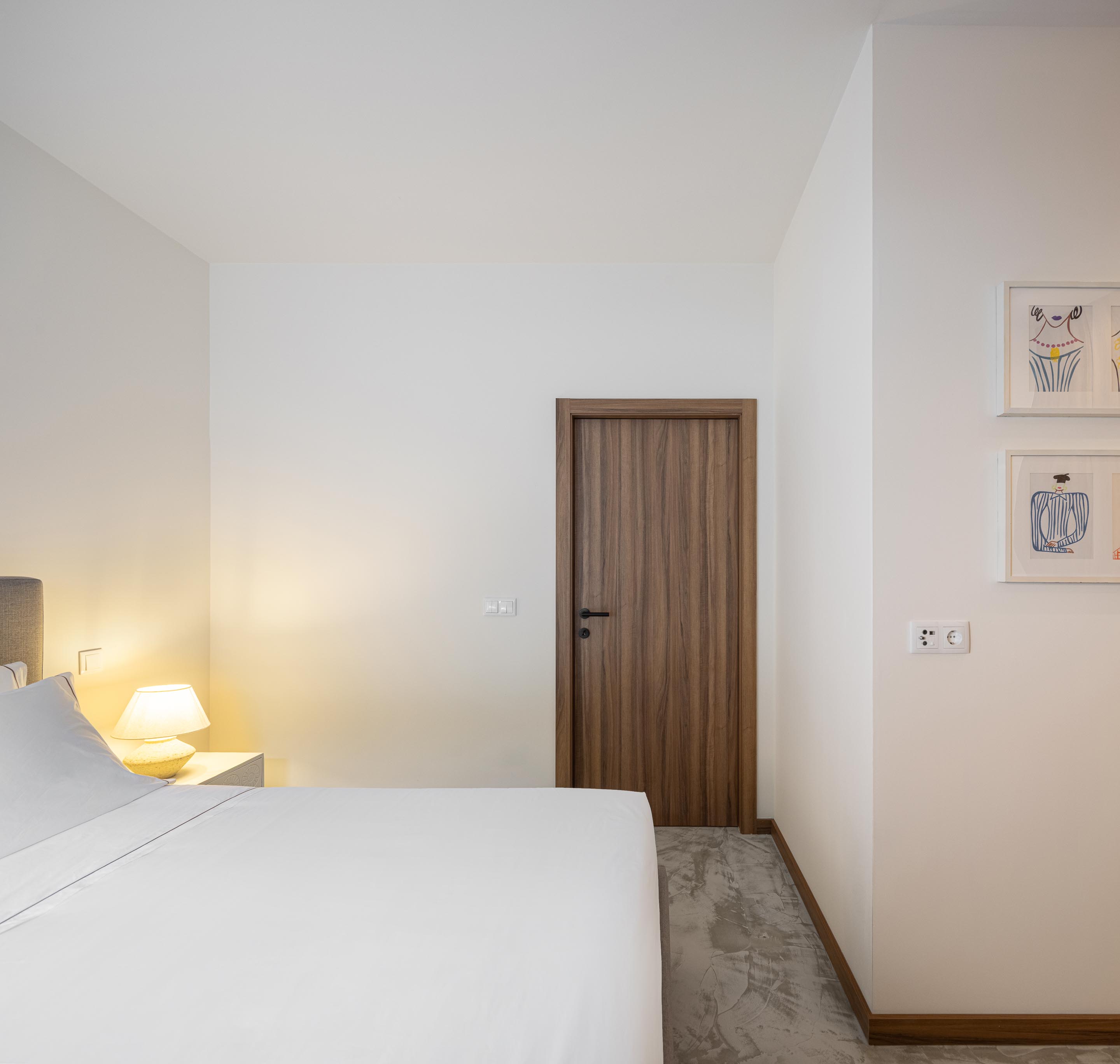 Quarto com pavimento em betão, paredes brancas e porta de madeira — Boutique Apartments arquitectura HPA fotografia Ivo Tavares