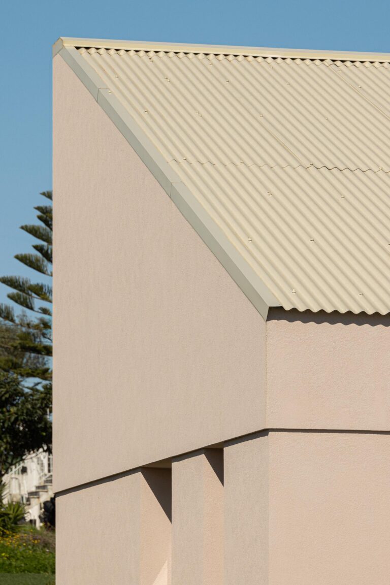 Canto da moradia com paredes em estuque rosa e cobertura inclinada em chapa metálica bege — Casa do Alpendre arquitectura Vasco Burnay Arquitectura fotografia Ivo Tavares