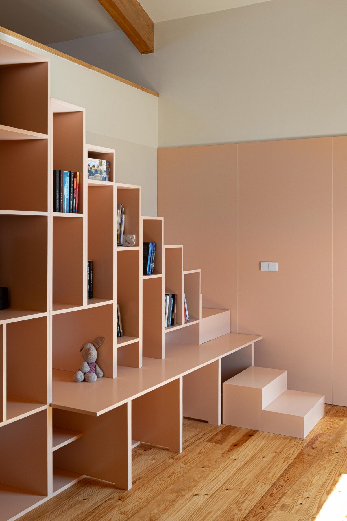 Quarto com pavimento em madeira e escada/estante multifuncional em carpintaria de cor pêssego — Casa do Alpendre arquitectura Vasco Burnay Arquitectura fotografia Ivo Tavares