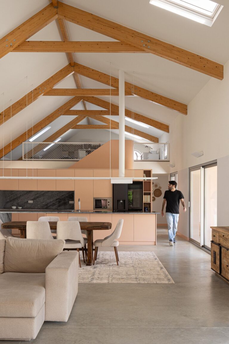 Interior de sala e cozinha em open space, com pé-direito duplo, estrutura de madeira e pavimento em betão — Casa do Alpendre arquitectura Vasco Burnay Arquitectura fotografia Ivo Tavares