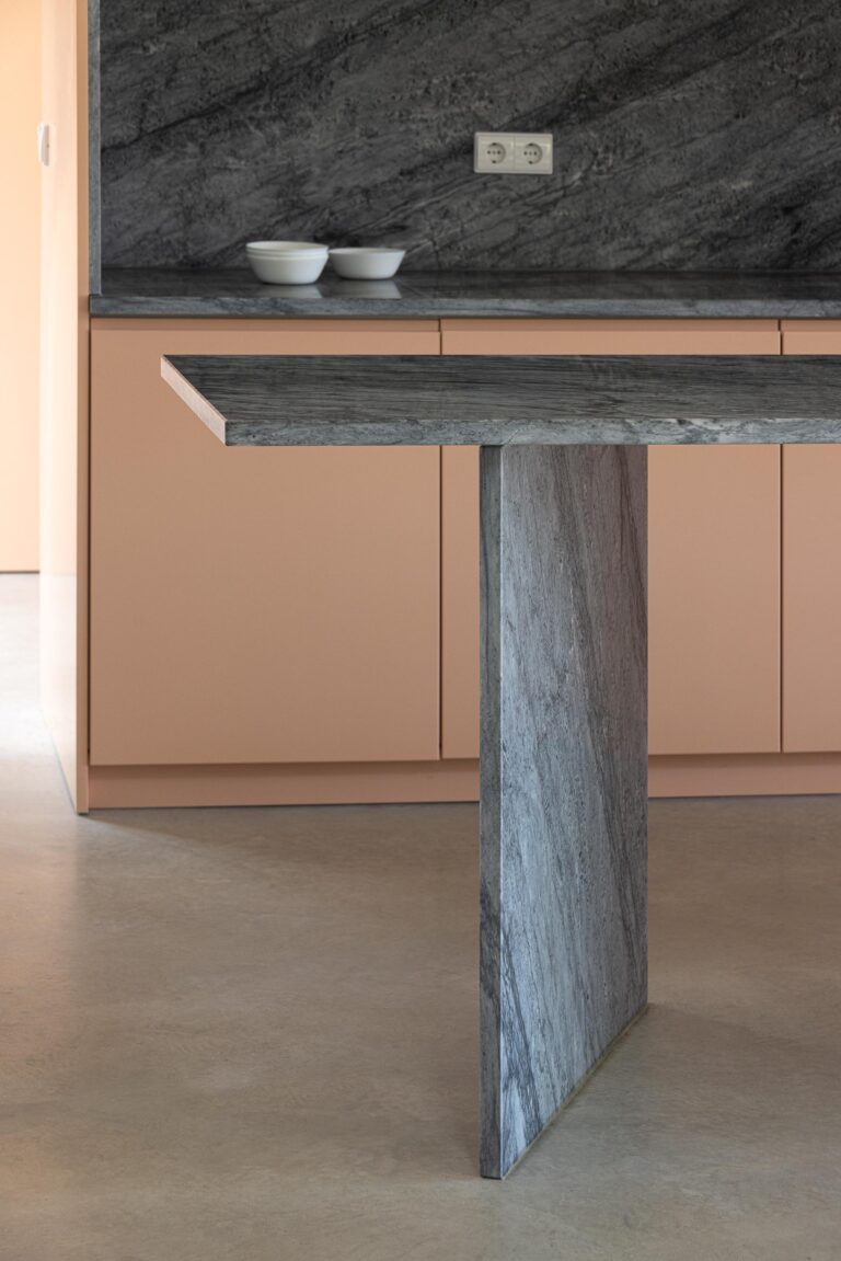 Detalhe da bancada da cozinha em mármore escuro com suporte vertical, sobre pavimento em betão — Casa do Alpendre arquitectura Vasco Burnay Arquitectura fotografia Ivo Tavares