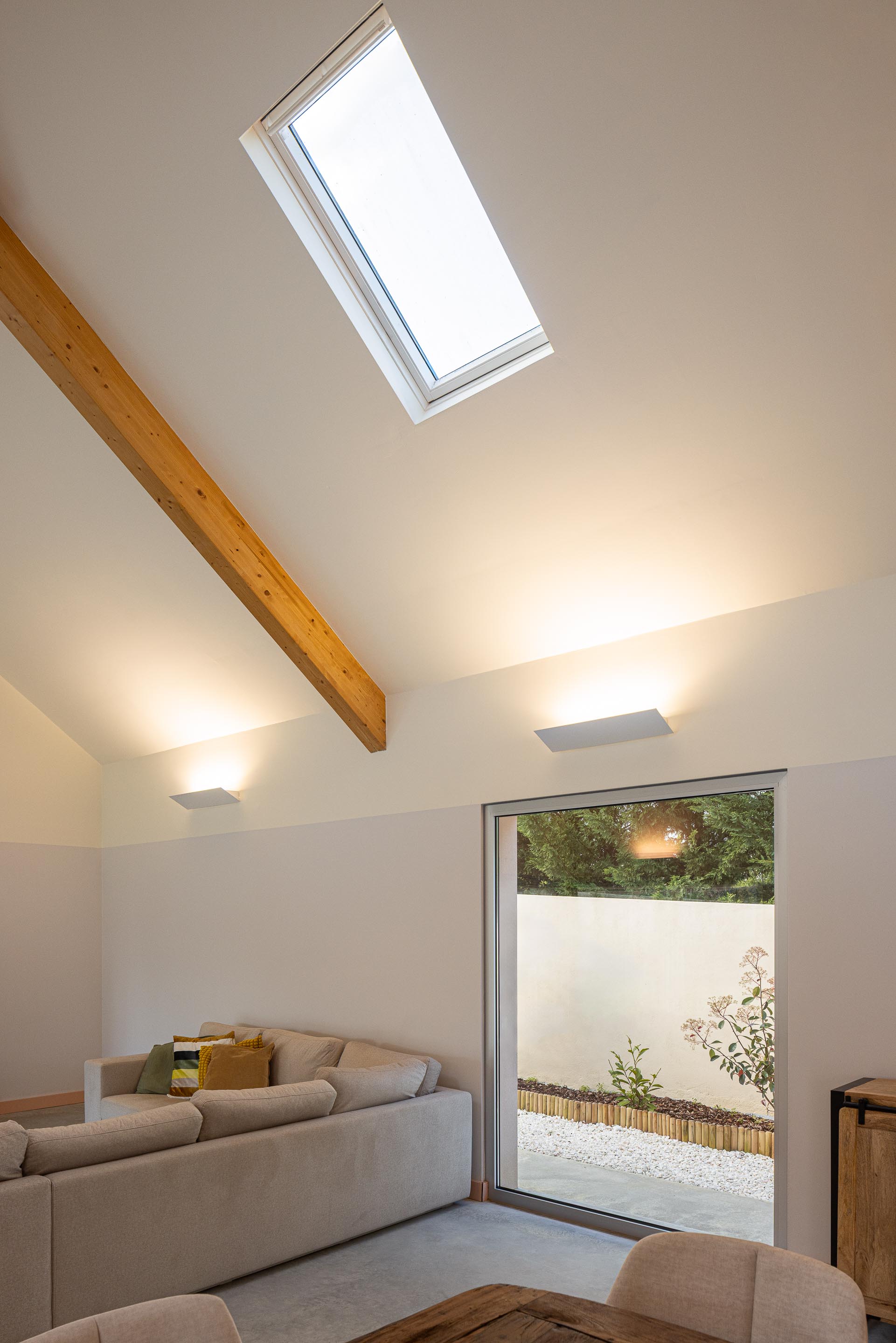 Sala de estar com sofá, porta de correr para o exterior e iluminação zenital por claraboia — Casa do Alpendre arquitectura Vasco Burnay Arquitectura fotografia Ivo Tavares
