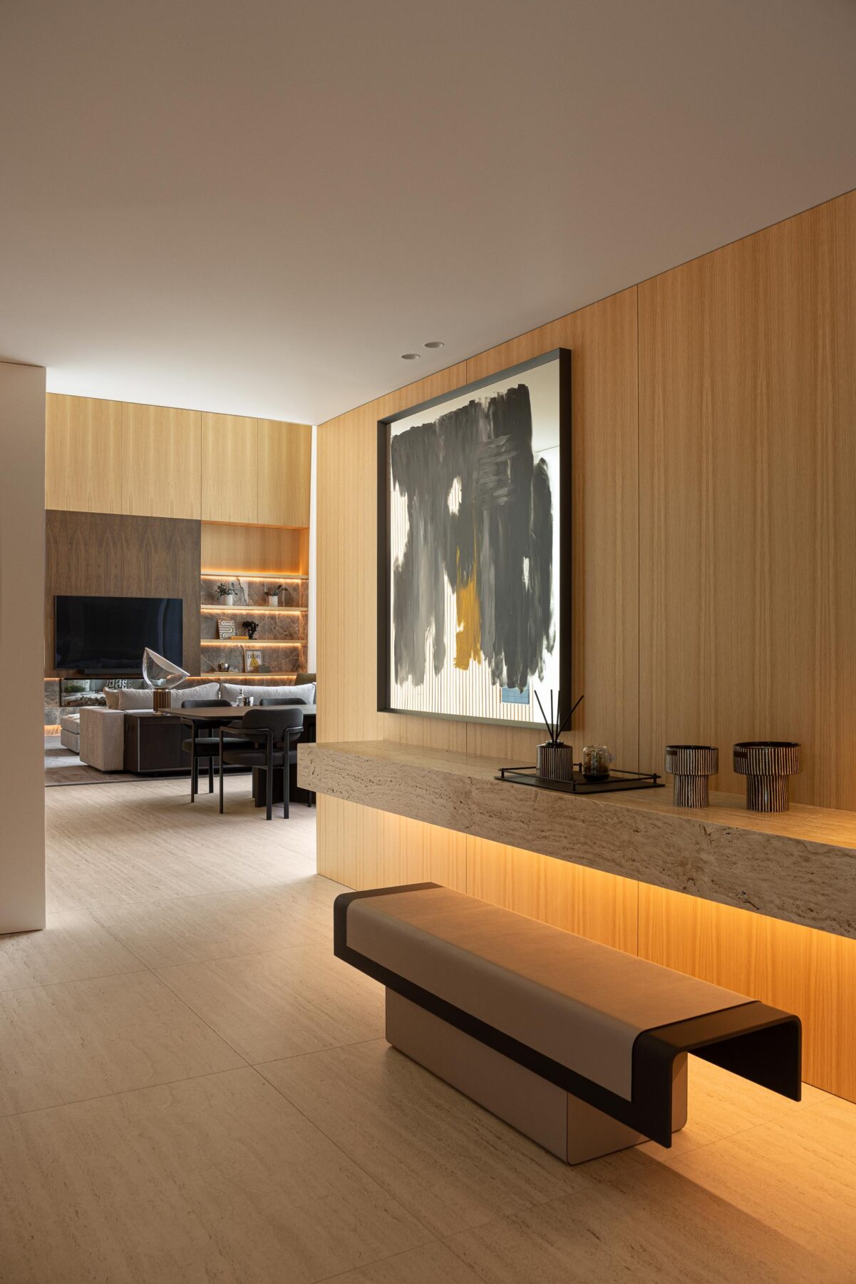 Corredor interior com paredes em madeira mel, pavimento em pedra clara e banco flutuante com iluminação indireta — Casa FJ arquitectura MIL870 + GRAUON fotografia Ivo Tavares