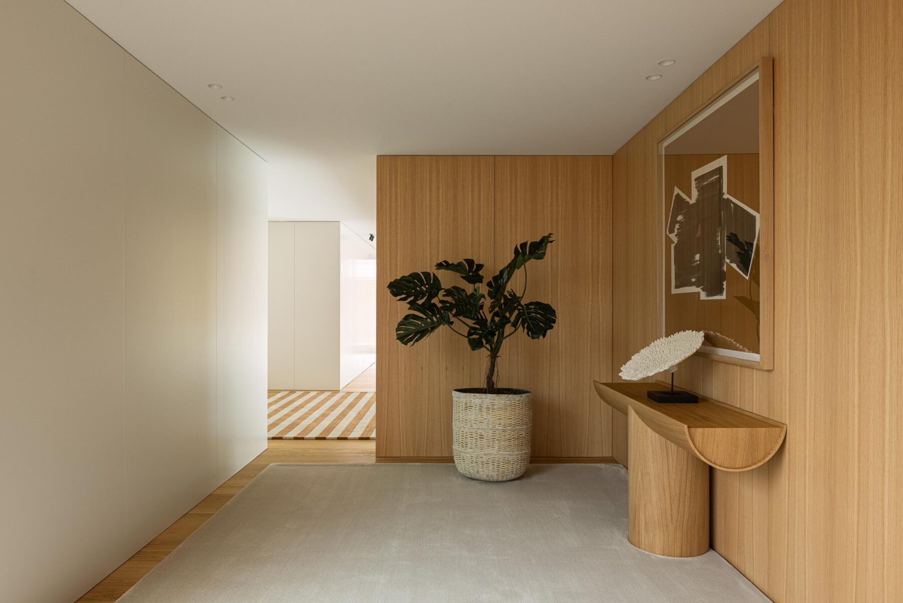 Corredor do pavimento superior com paredes brancas, revestimento em madeira mel e pavimento em madeira clara — Casa FJ arquitectura MIL870 + GRAUON fotografia Ivo Tavares