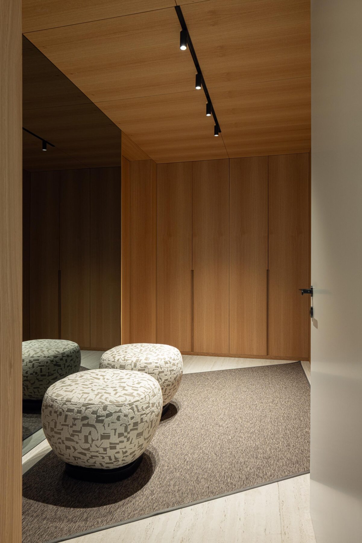 Closet com paredes em madeira mel, espelho de corpo inteiro e pavimento em pedra clara — Casa FJ arquitectura MIL870 + GRAUON fotografia Ivo Tavares
