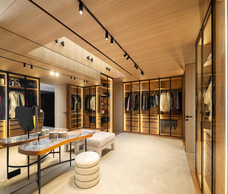 Closet principal com teto em madeira mel, armários envidraçados iluminados e iluminação zenital — Casa FJ arquitectura MIL870 + GRAUON fotografia Ivo Tavares