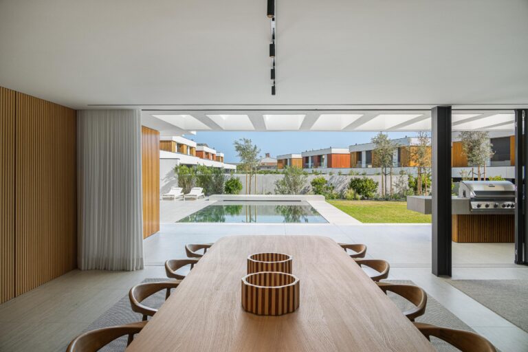 Sala de jantar com grandes vãos envidraçados, revelando piscina e jardim, promovendo continuidade — Casa FJ arquitectura MIL870 + GRAUON fotografia Ivo Tavares