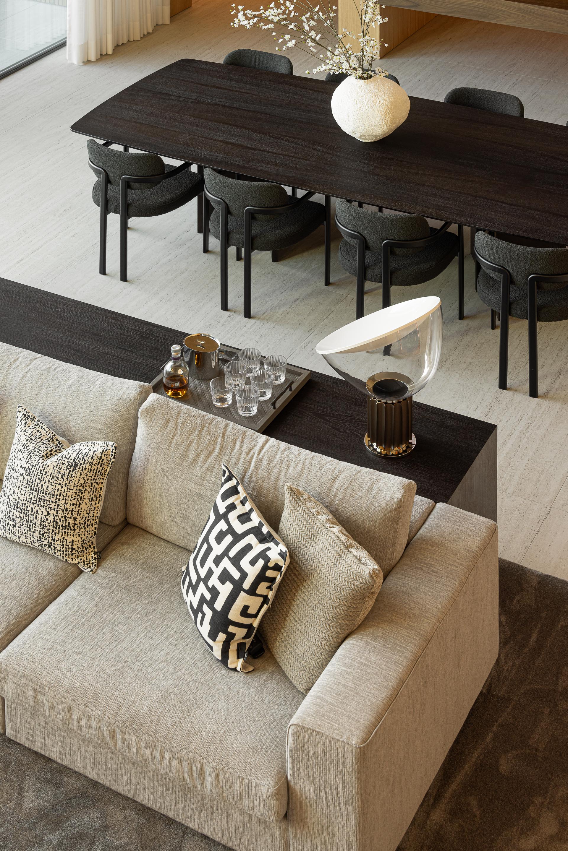 Sala de estar e jantar com sofá modular, mesa de jantar escura e pavimento em alcatifa — Casa FJ arquitectura MIL870 + GRAUON fotografia Ivo Tavares