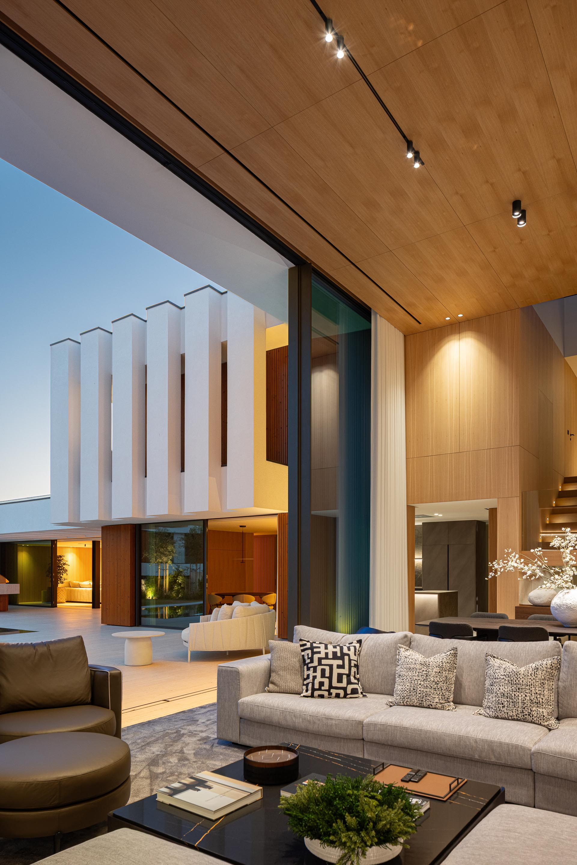 Fachada posterior com volumes brancos, grandes vãos envidraçados e piscina iluminada — Casa FJ arquitectura MIL870 + GRAUON fotografia Ivo Tavares