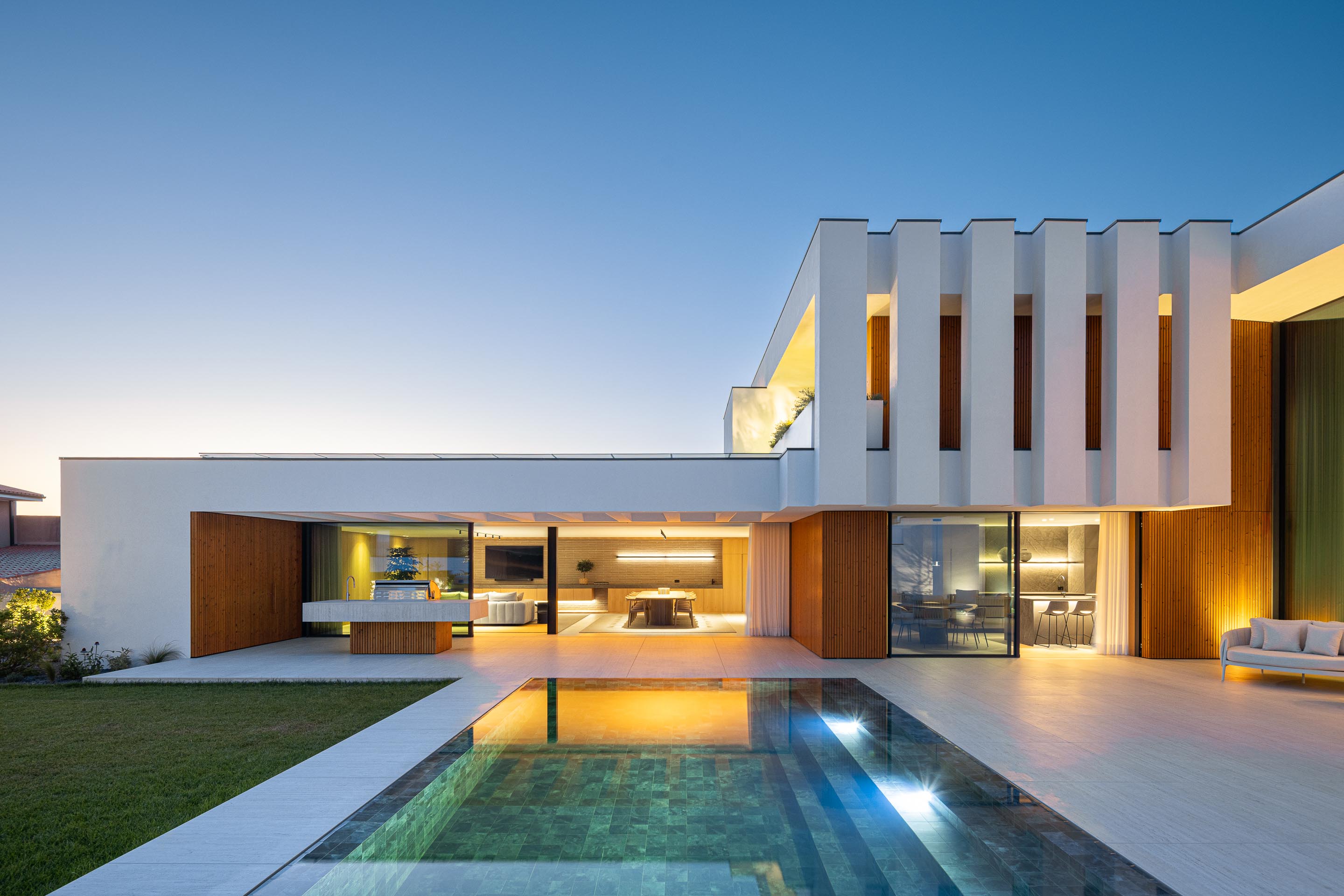 Casa de banho com paredes e lavatório em mármore vermelho, espelho grande e porta em madeira clara — Casa FJ arquitectura MIL870 + GRAUON fotografia Ivo Tavares