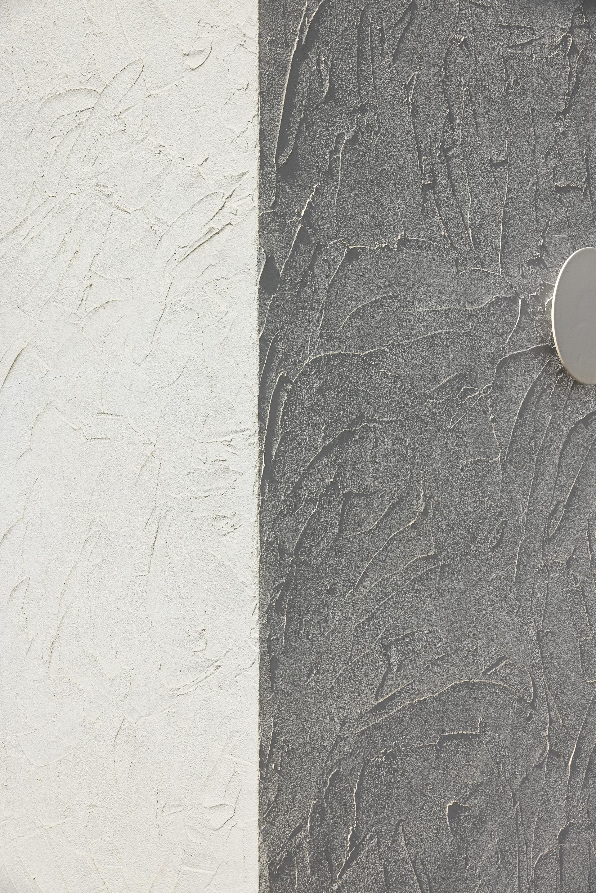 Detalhe da fachada com textura rugosa em branco e cinzento, sob luz e sombra — CASA ÂNCORA arquitectura Tiago Sousa Arquitecto fotografia Ivo Tavares