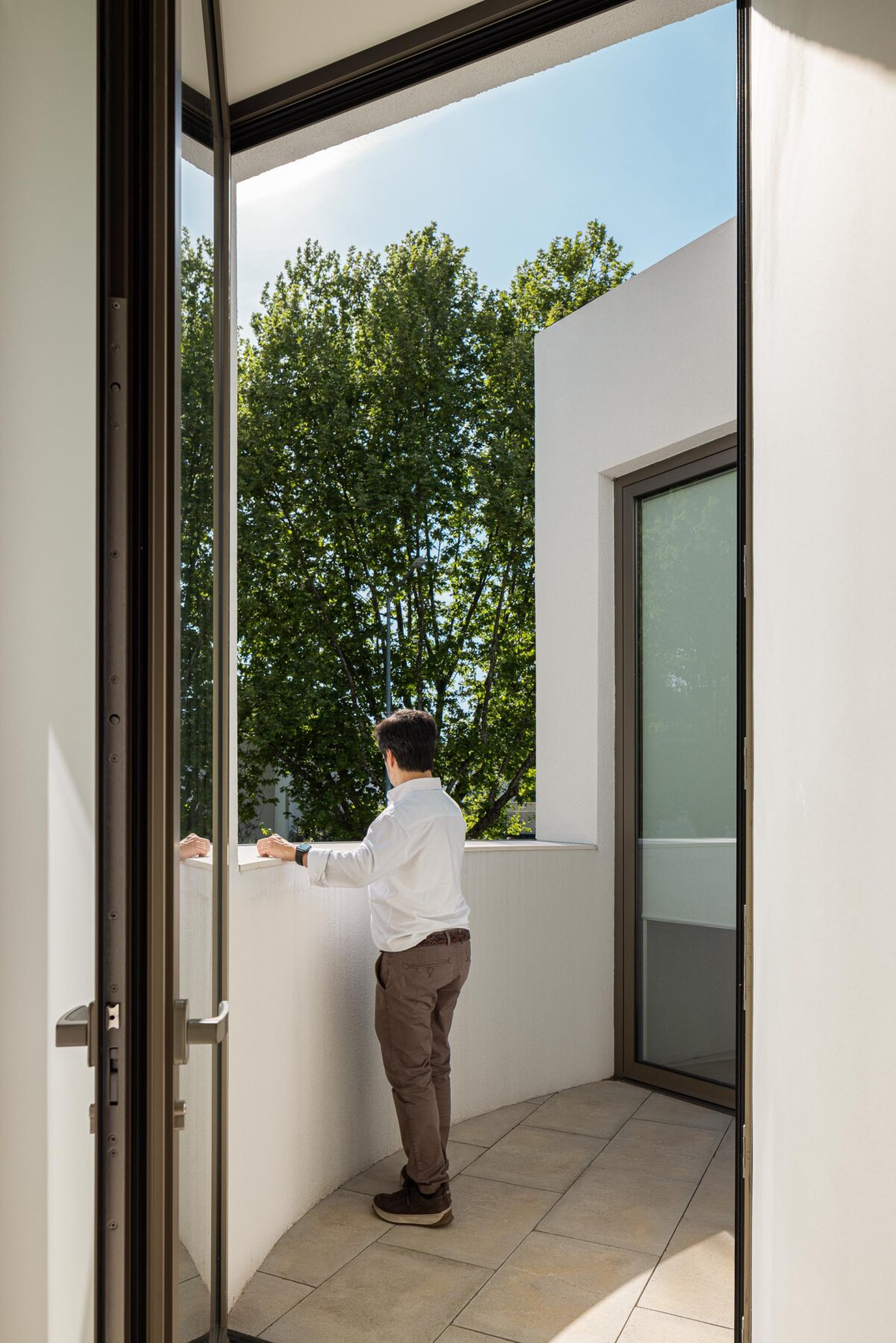 Sala de reuniões com paredes brancas e acesso a varanda exterior, com vista para vegetação — Farmácia São João arquitectura Tsou Arquitectos fotografia Ivo Tavares