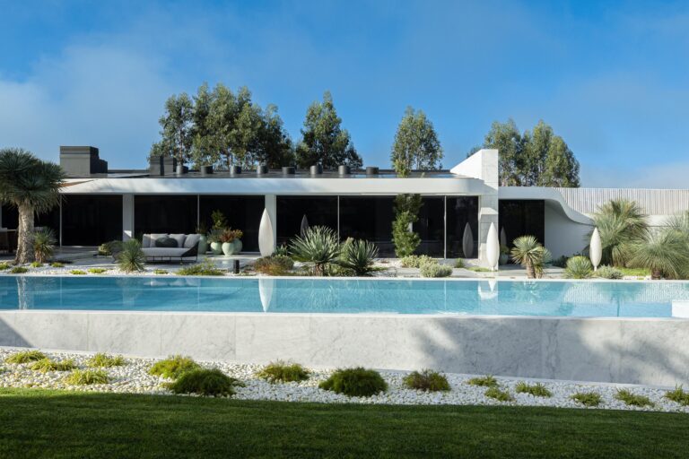 Fachada posterior da moradia com volume horizontal, grandes vãos escurecidos e piscina infinita em mármore branco — RiscoWhite arquitectura Risco Singular – Arquitectura, Lda. fotografia Ivo Tavares