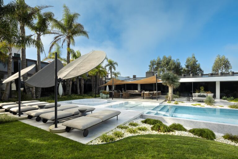 Área de lazer exterior com piscina, espreguiçadeiras, guarda-sóis e zona de refeições, rodeada por palmeiras — RiscoWhite arquitectura Risco Singular – Arquitectura, Lda. fotografia Ivo Tavares
