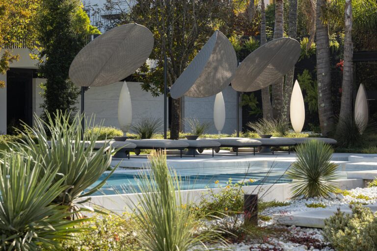 Detalhe da piscina e zona de estar exterior, com pavimento de mármore branco e vegetação variada — RiscoWhite arquitectura Risco Singular – Arquitectura, Lda. fotografia Ivo Tavares