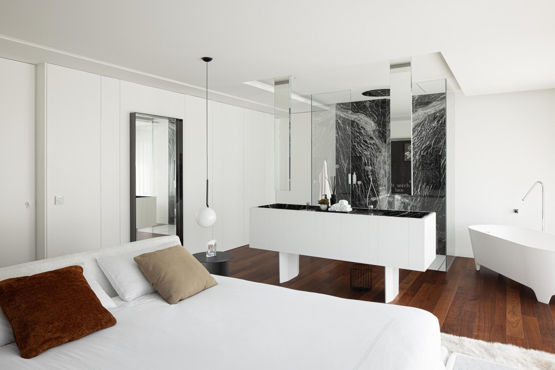 Quarto com pavimento em madeira, banheira freestanding e casa de banho integrada com lavatório e mármore negro — RiscoWhite arquitectura Risco Singular – Arquitectura, Lda. fotografia Ivo Tavares