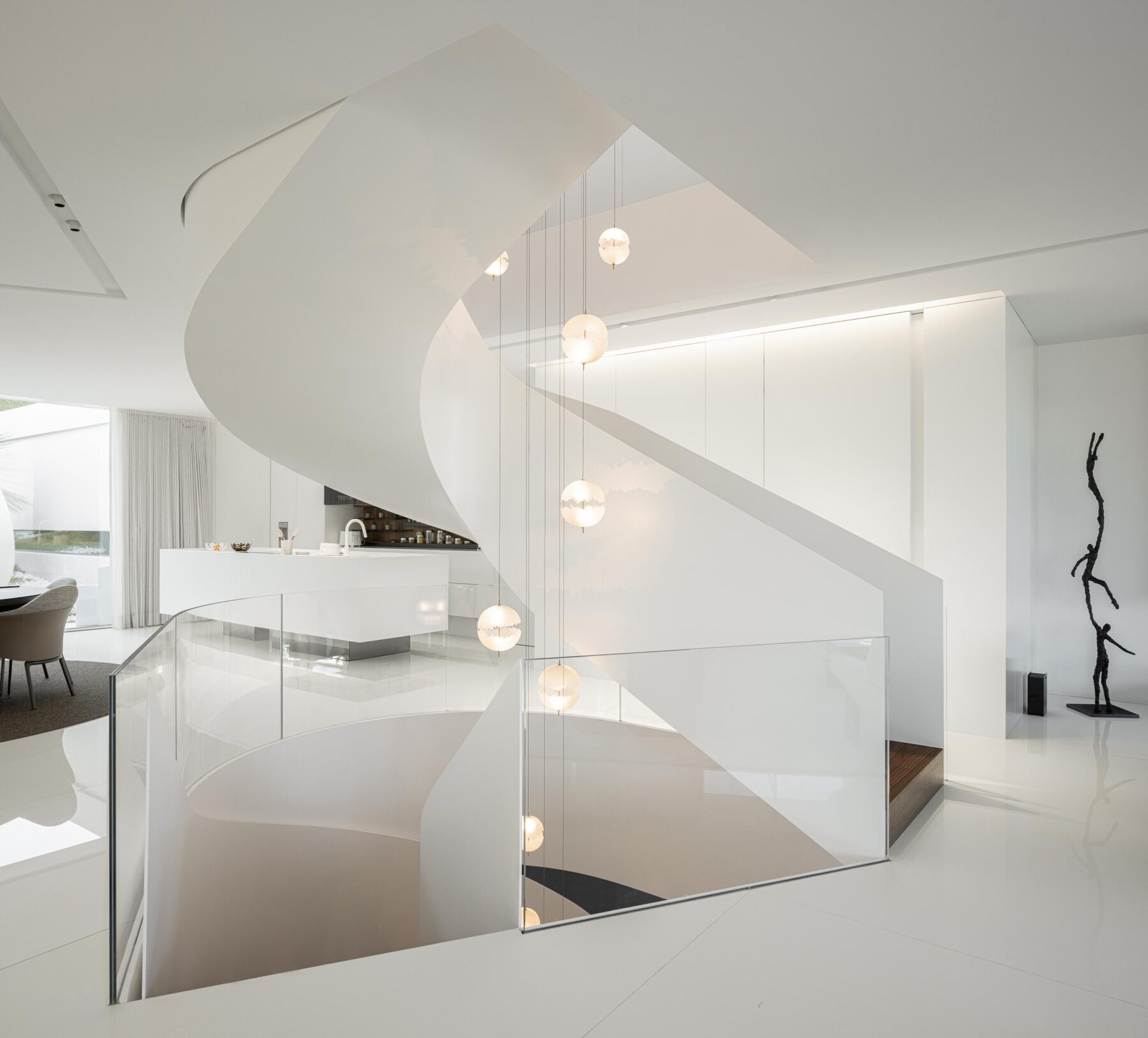 Escada em caracol branca com guarda-corpos em vidro estrutural, iluminada por candeeiros esféricos suspensos — RiscoWhite arquitectura Risco Singular – Arquitectura, Lda. fotografia Ivo Tavares