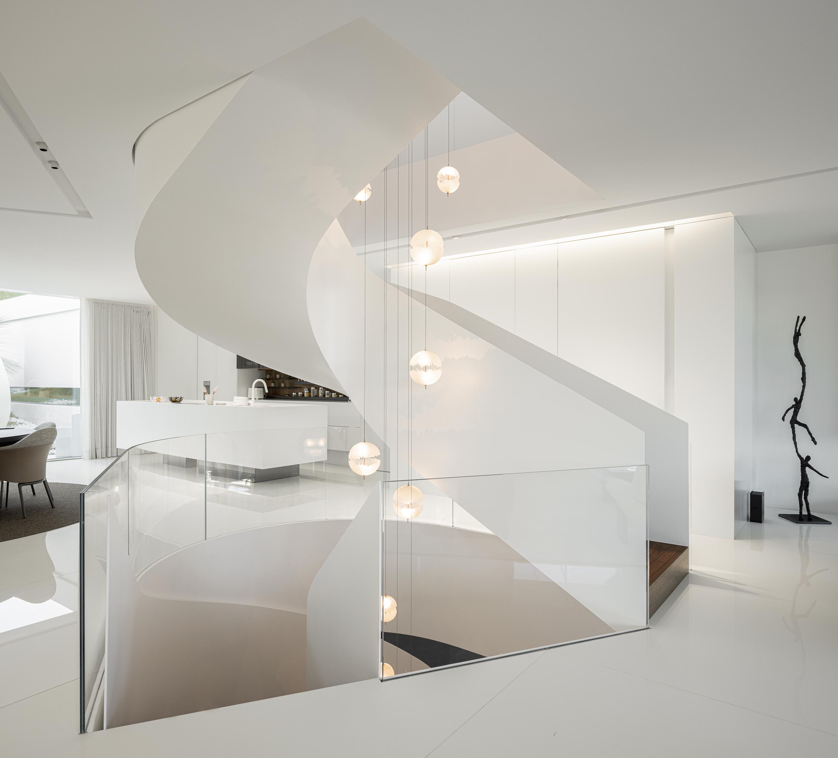 Escada em caracol branca com guarda-corpos em vidro estrutural, iluminada por candeeiros esféricos suspensos — RiscoWhite arquitectura Risco Singular – Arquitectura, Lda. fotografia Ivo Tavares