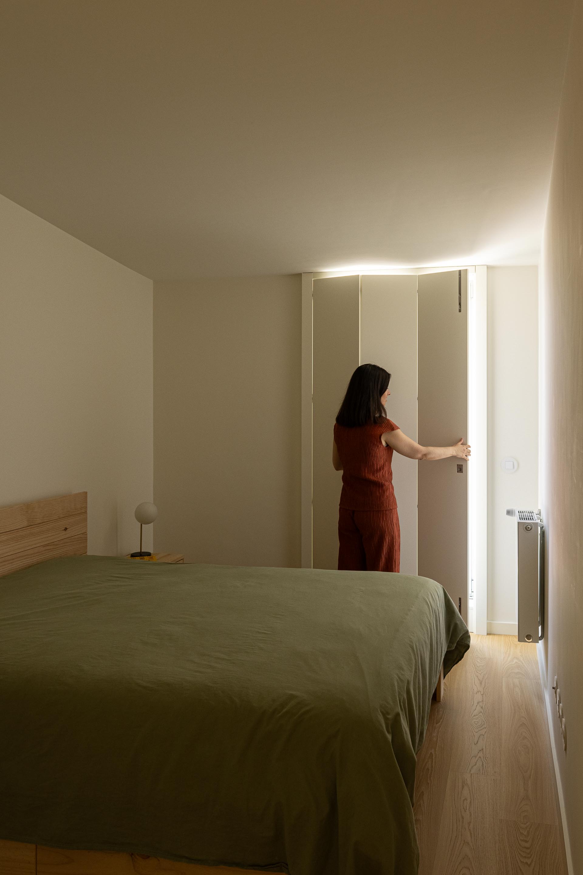 Quarto com pavimento em madeira clara, cama em madeira e roupeiro branco, iluminado por luz natural — Costa Cabral Building arquitectura ENTRETEMPOS + ATA Atelier fotografia Ivo Tavares