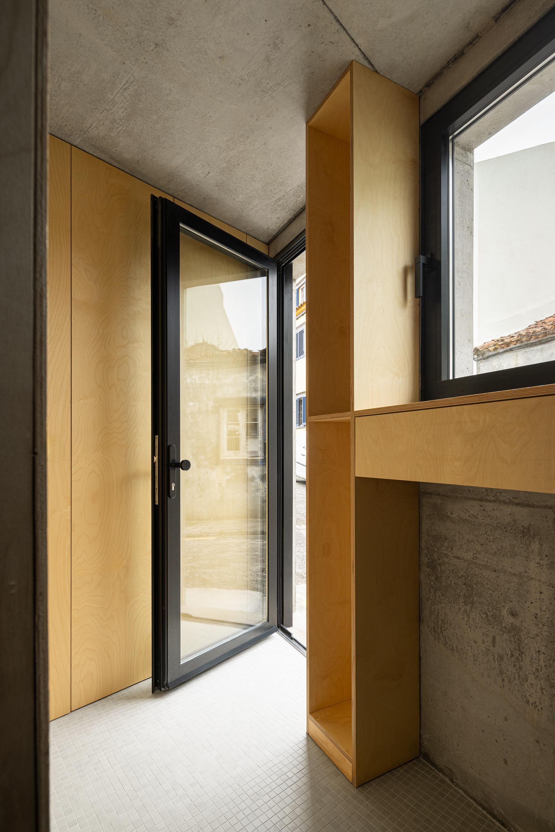 Hall de entrada com pavimento em mosaico branco, paredes em betão aparente e mobiliário fixo em madeira clara — MINI ATALHADA arquitectura SO Arquitetura & Design fotografia Ivo Tavares