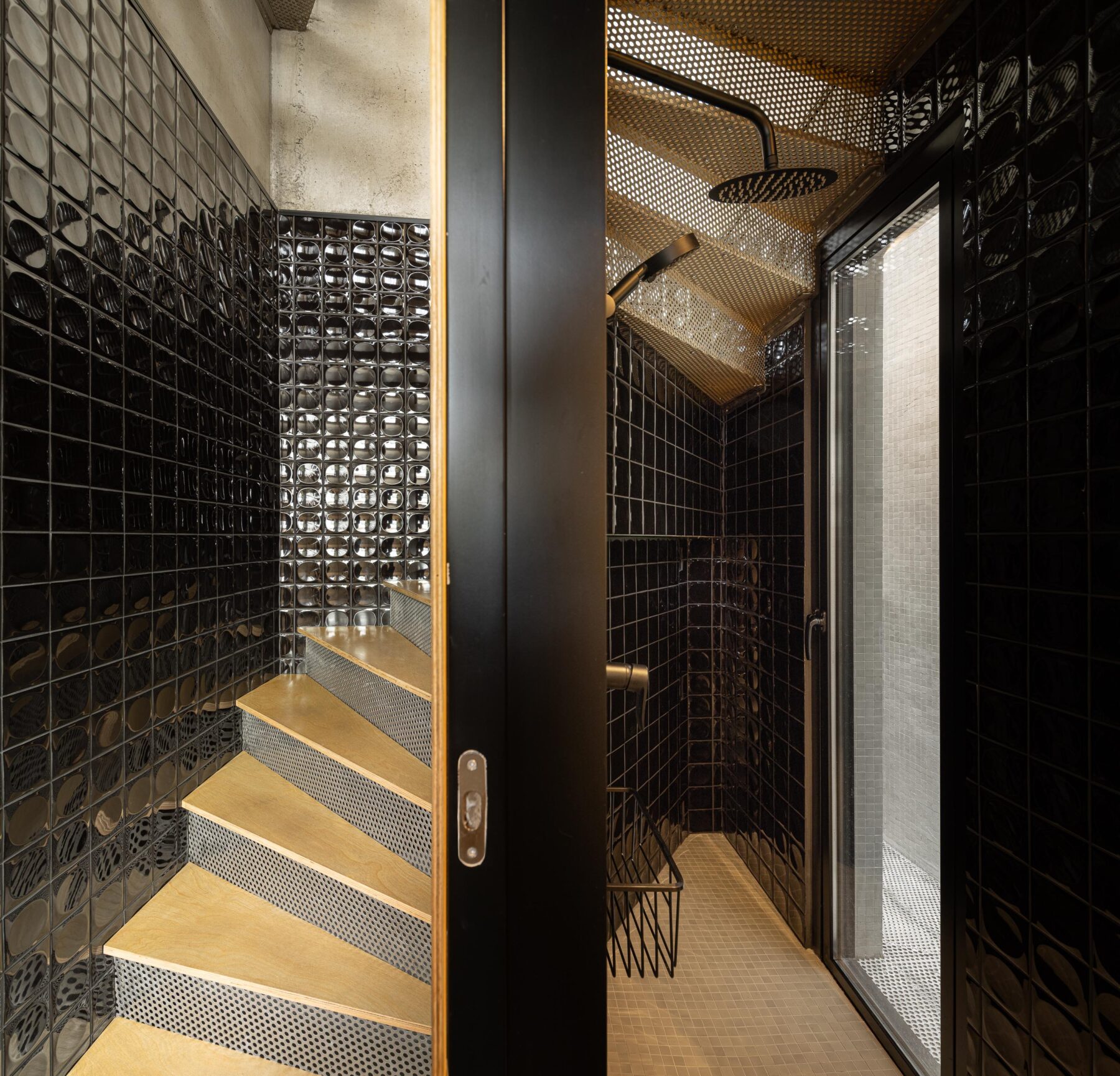 Escada em chapa metálica perfurada e madeira, adjacente a duche com paredes em azulejo preto brilhante — MINI ATALHADA arquitectura SO Arquitetura & Design fotografia Ivo Tavares