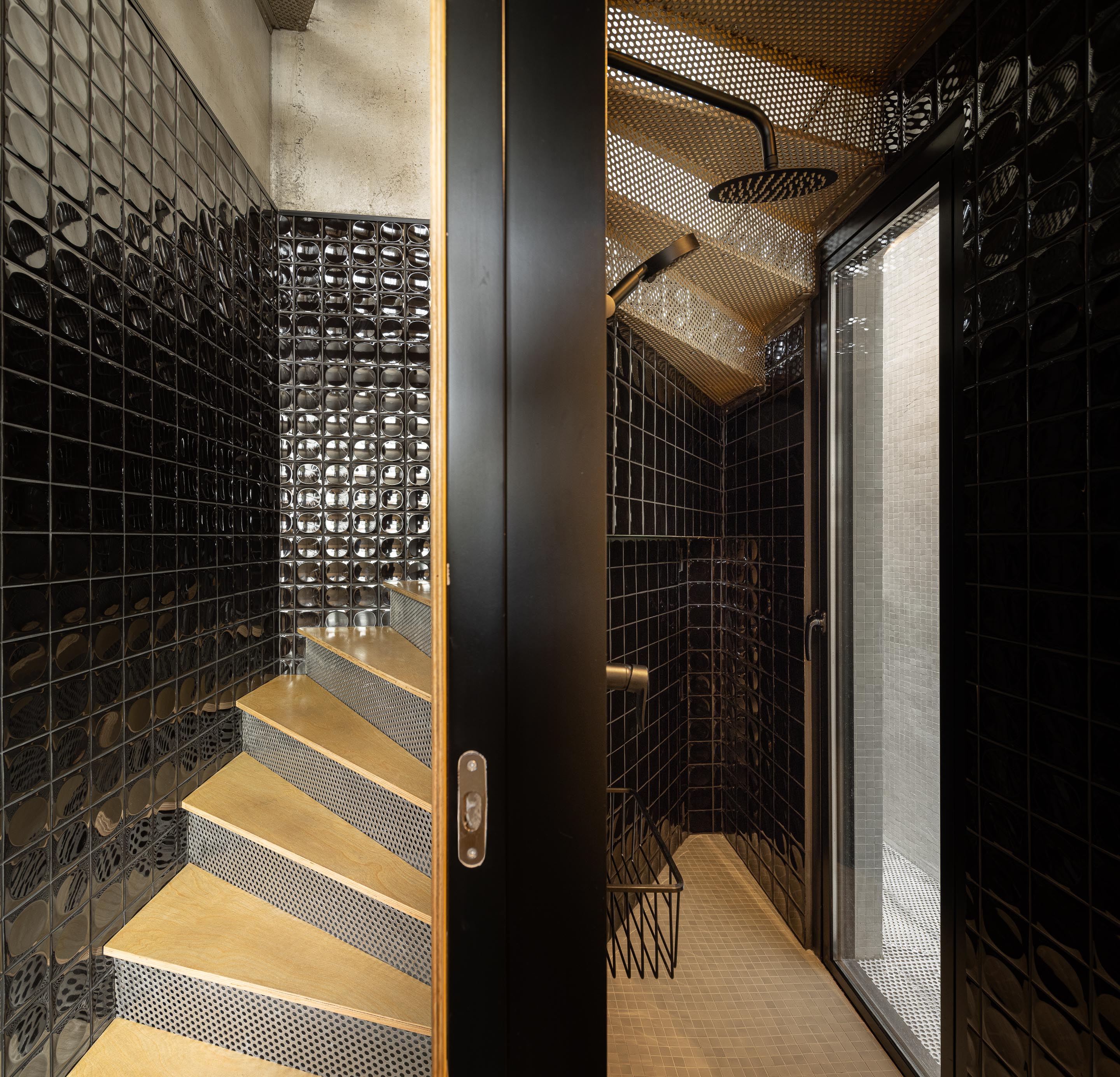 Escada em chapa metálica perfurada e madeira, adjacente a duche com paredes em azulejo preto brilhante — MINI ATALHADA arquitectura SO Arquitetura & Design fotografia Ivo Tavares