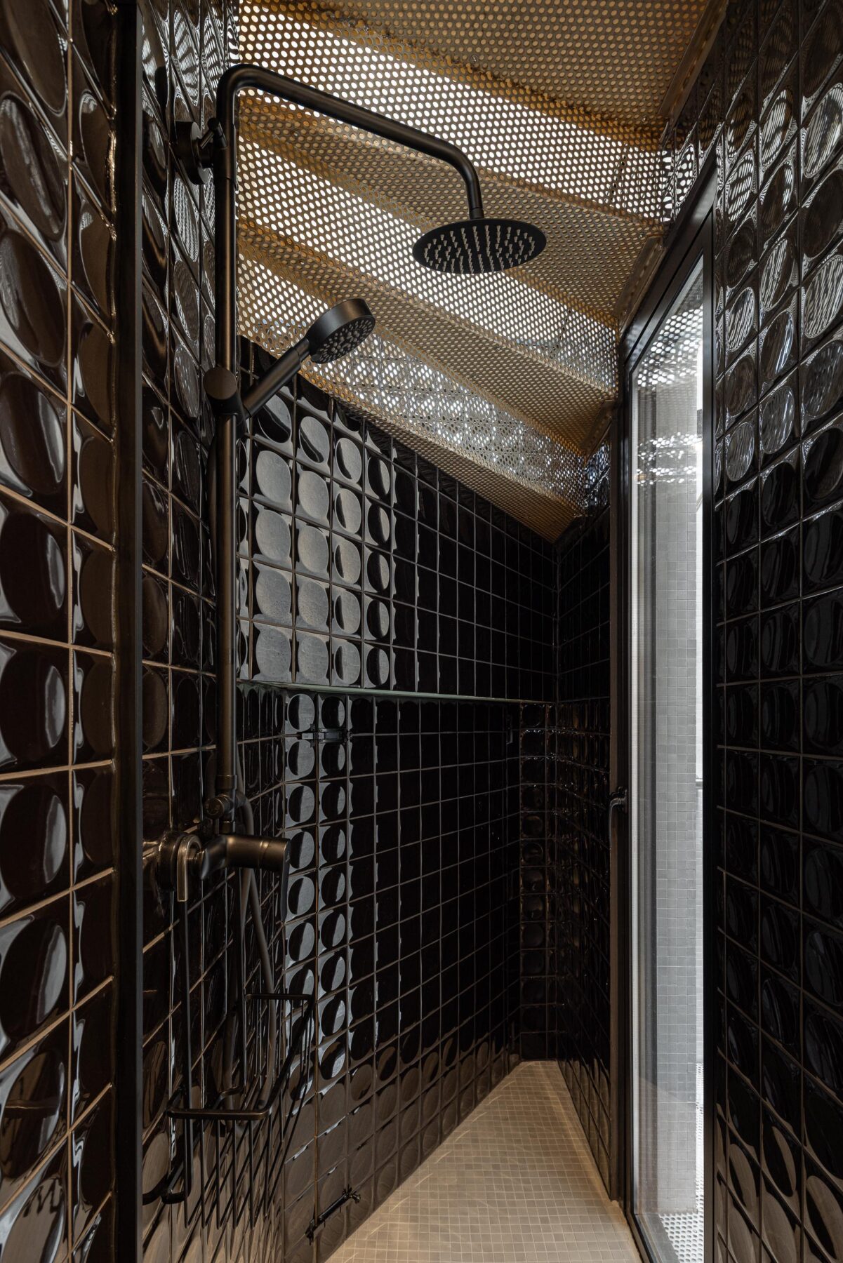 Duche com paredes em azulejo preto brilhante, teto inclinado em chapa metálica perfurada e chuveiro preto — MINI ATALHADA arquitectura SO Arquitetura & Design fotografia Ivo Tavares