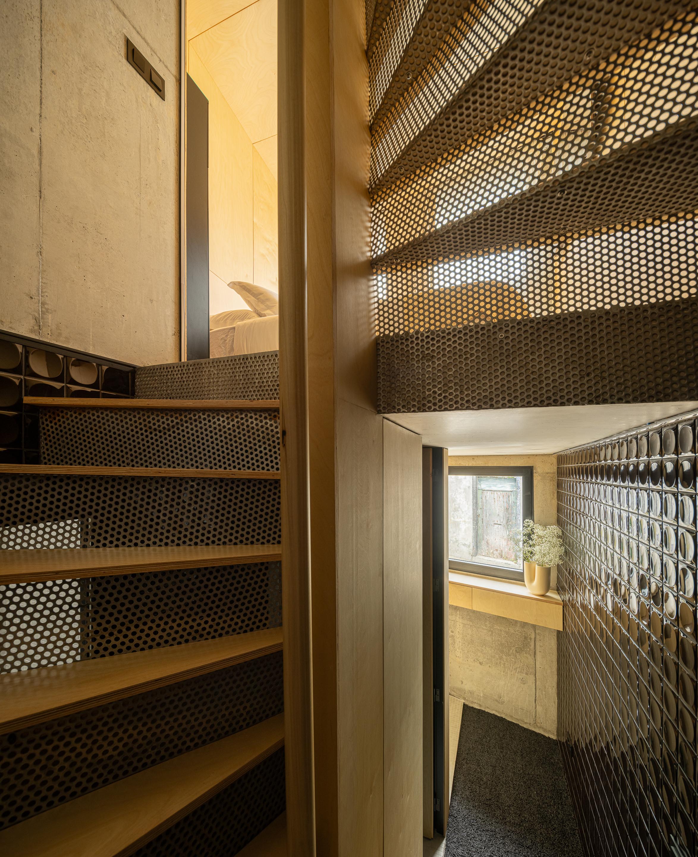 Escada compacta em chapa metálica perfurada e madeira clara, com paredes em betão aparente — MINI ATALHADA arquitectura SO Arquitetura & Design fotografia Ivo Tavares