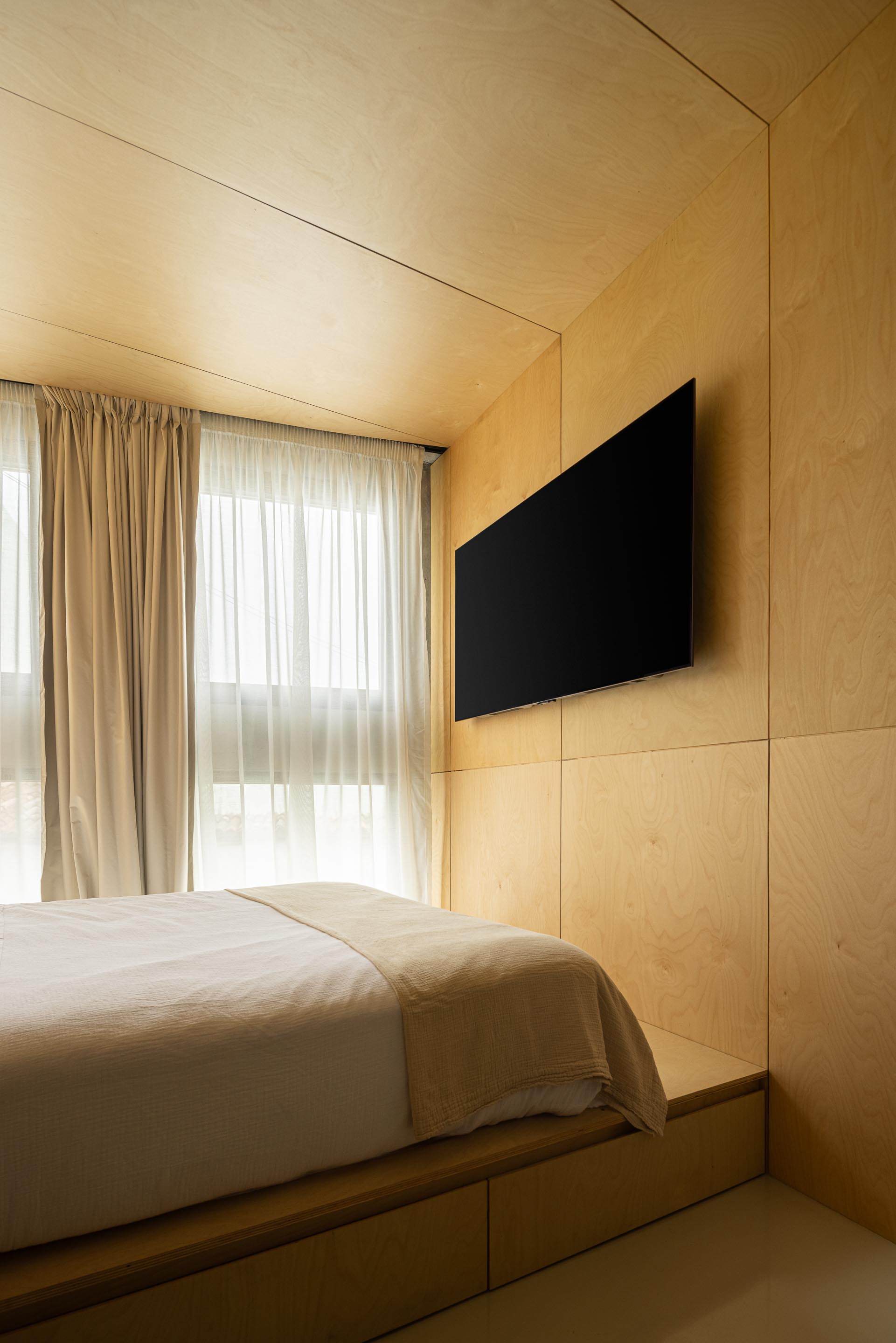 Quarto com paredes e teto revestidos em madeira clara, cama e televisão embutida — MINI ATALHADA arquitectura SO Arquitetura & Design fotografia Ivo Tavares