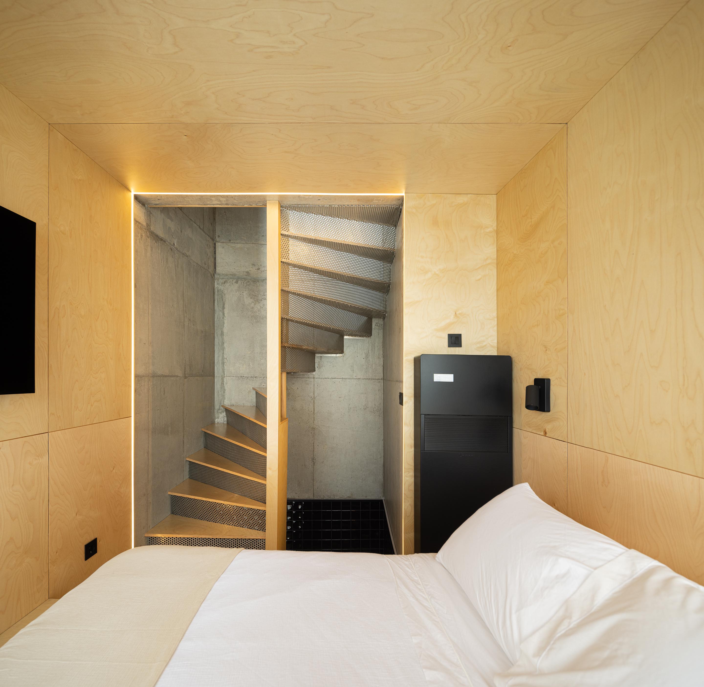 Quarto com paredes em madeira clara, acesso à escada em betão aparente e chapa metálica perfurada — MINI ATALHADA arquitectura SO Arquitetura & Design fotografia Ivo Tavares