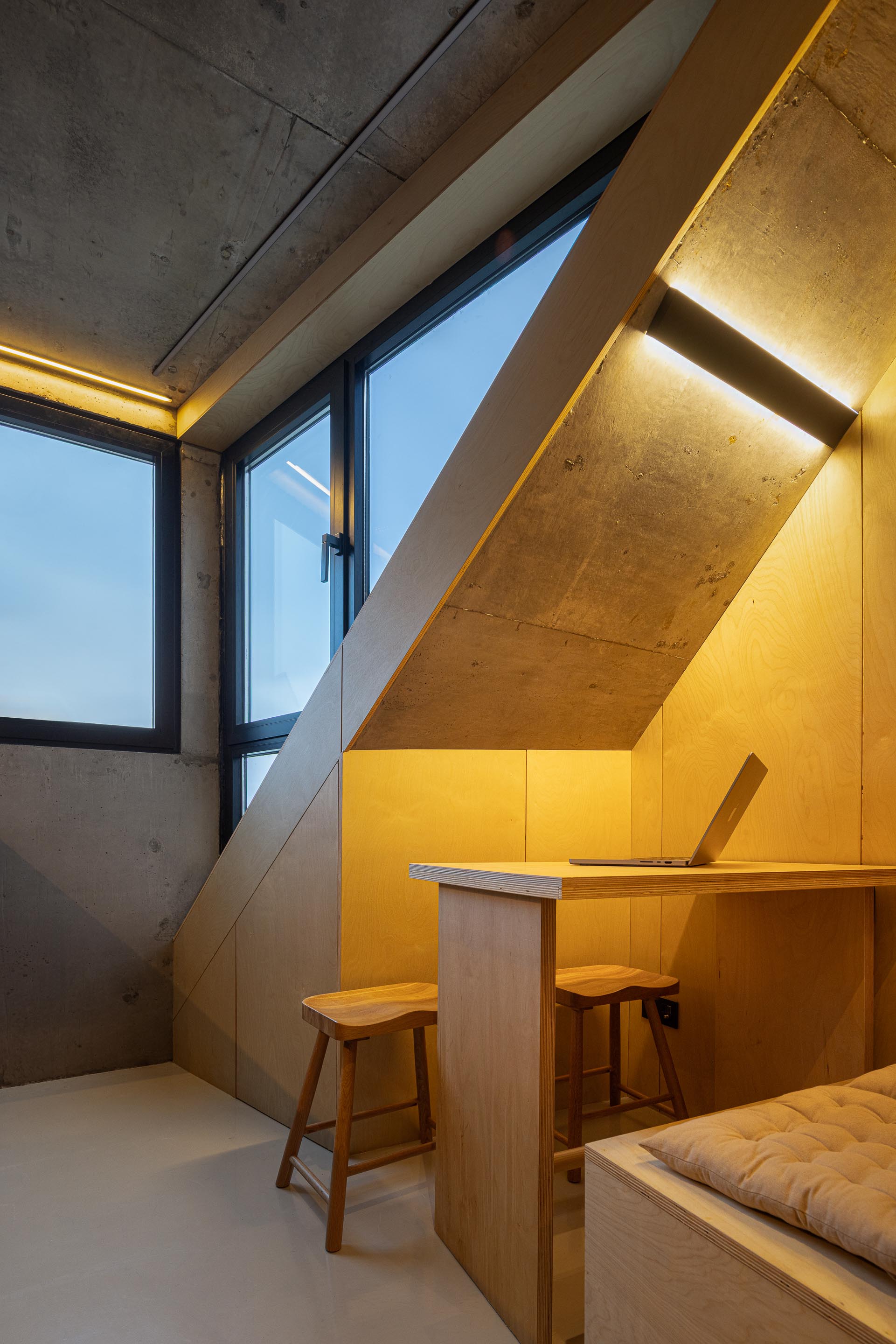 Zona de trabalho com secretária embutida em madeira clara, paredes em betão aparente e vãos amplos — MINI ATALHADA arquitectura SO Arquitetura & Design fotografia Ivo Tavares