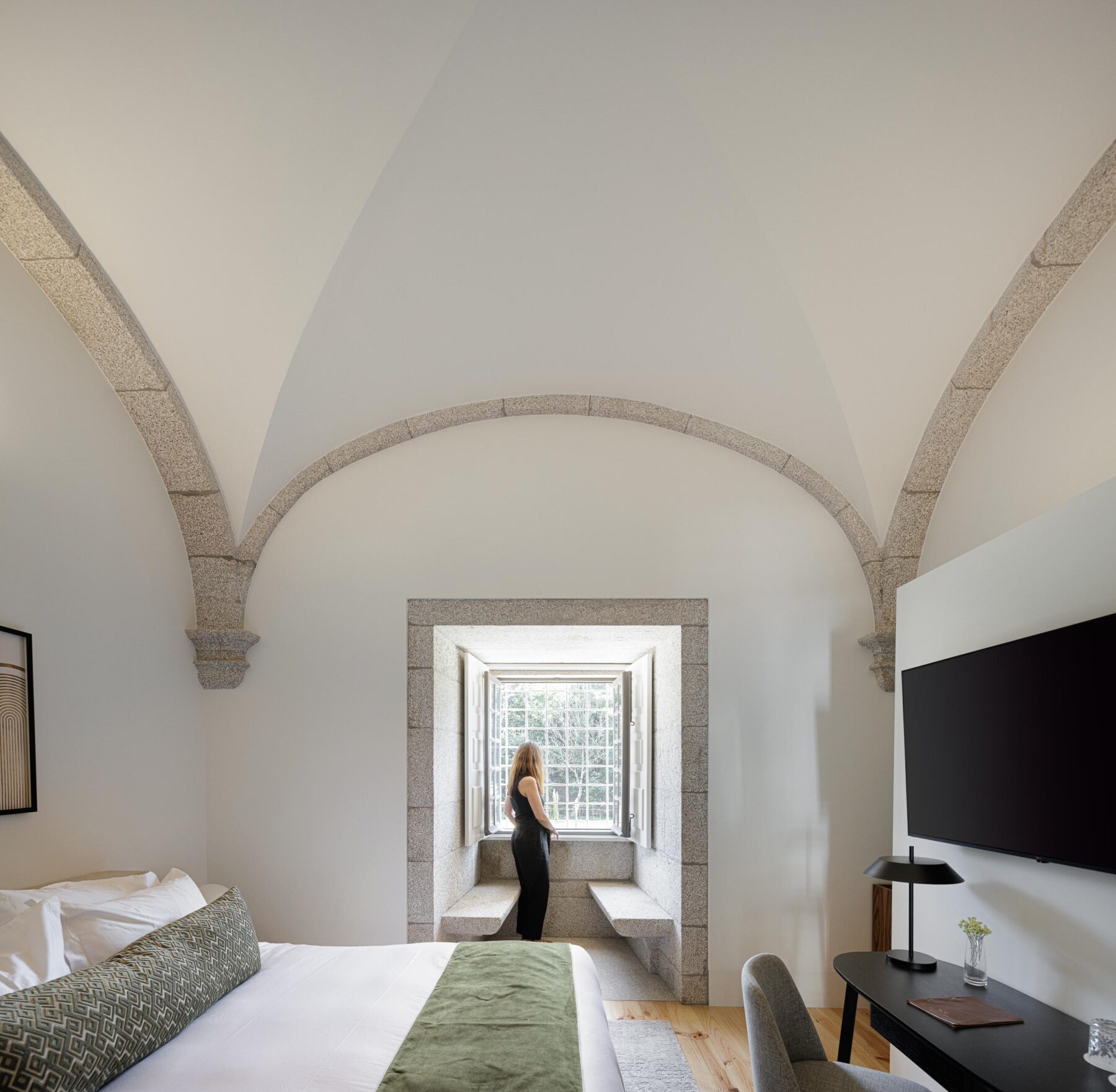 Quarto com abóbadas de pedra e teto branco, pavimento em madeira clara e janela em pedra, com secretária — MS COLLECTION AROUCA arquitectura MIMOOL ARQUITECTURA & INTERIORES fotografia Ivo Tavares
