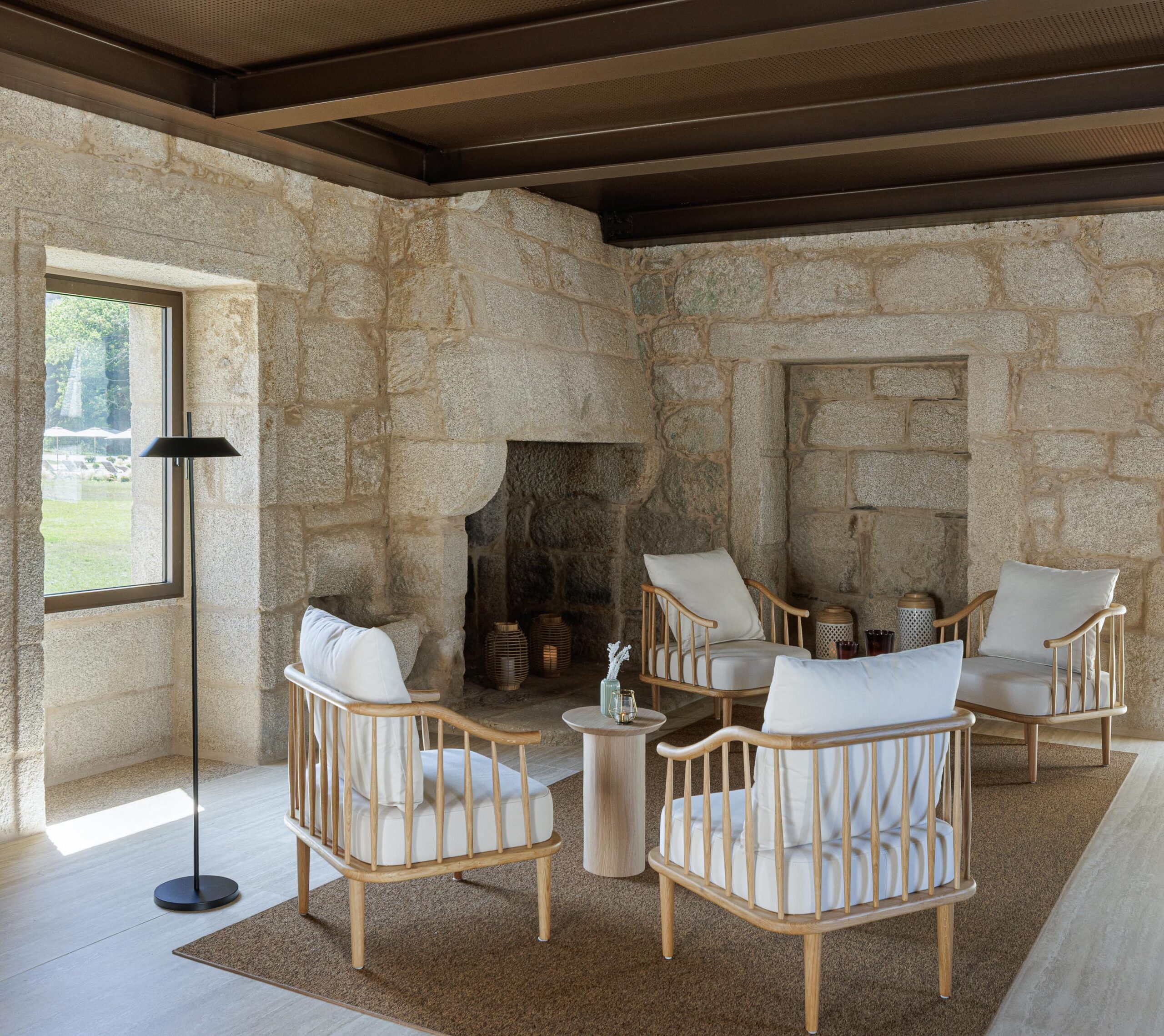 Sala de estar com paredes em pedra aparente, teto em madeira escura e mobiliário em madeira clara — MS COLLECTION AROUCA arquitectura MIMOOL ARQUITECTURA & INTERIORES fotografia Ivo Tavares