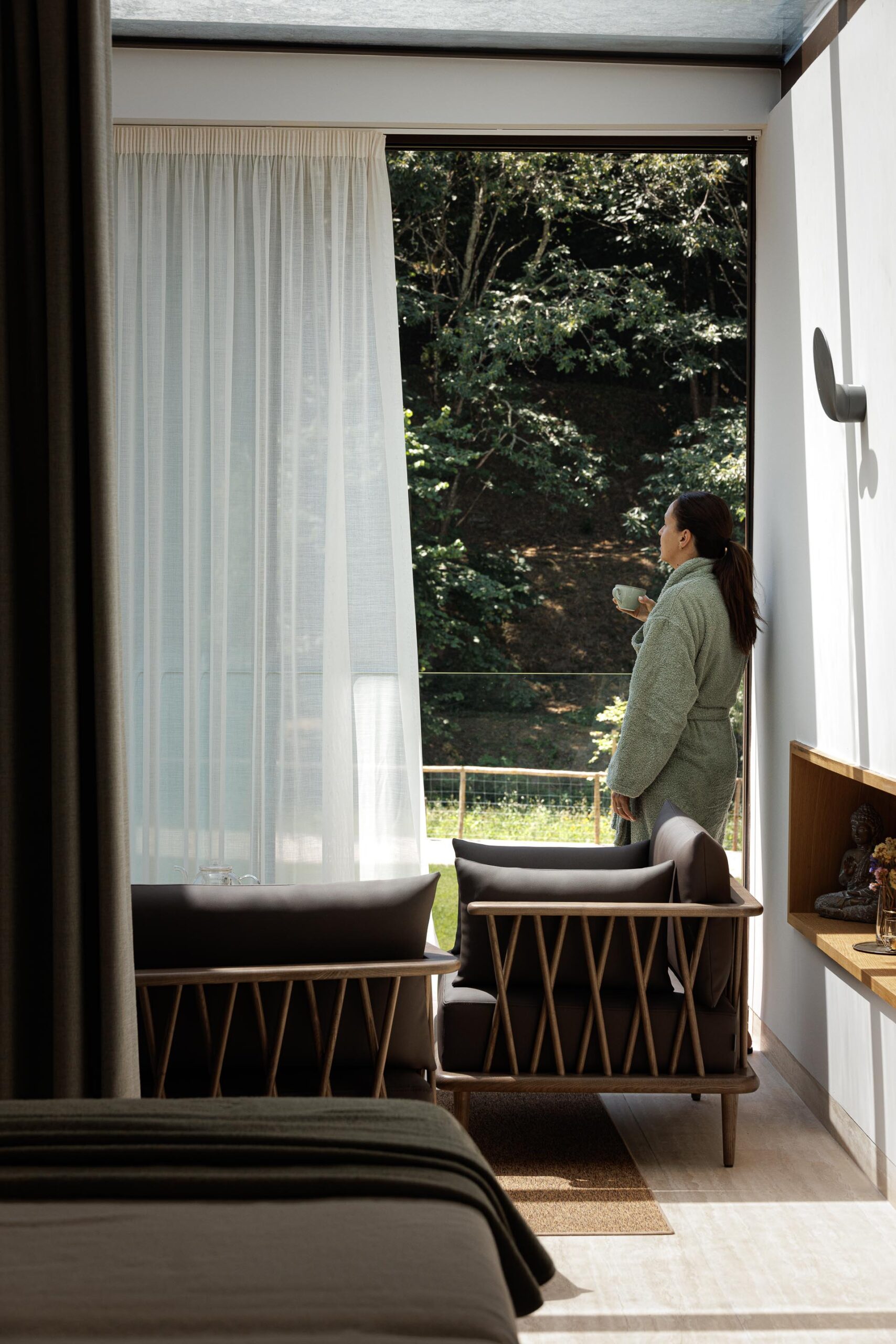 Quarto com vista para a vegetação, com poltronas escuras e cortinas claras, criando um ambiente tranquilo — MS COLLECTION AROUCA arquitectura MIMOOL ARQUITECTURA & INTERIORES fotografia Ivo Tavares