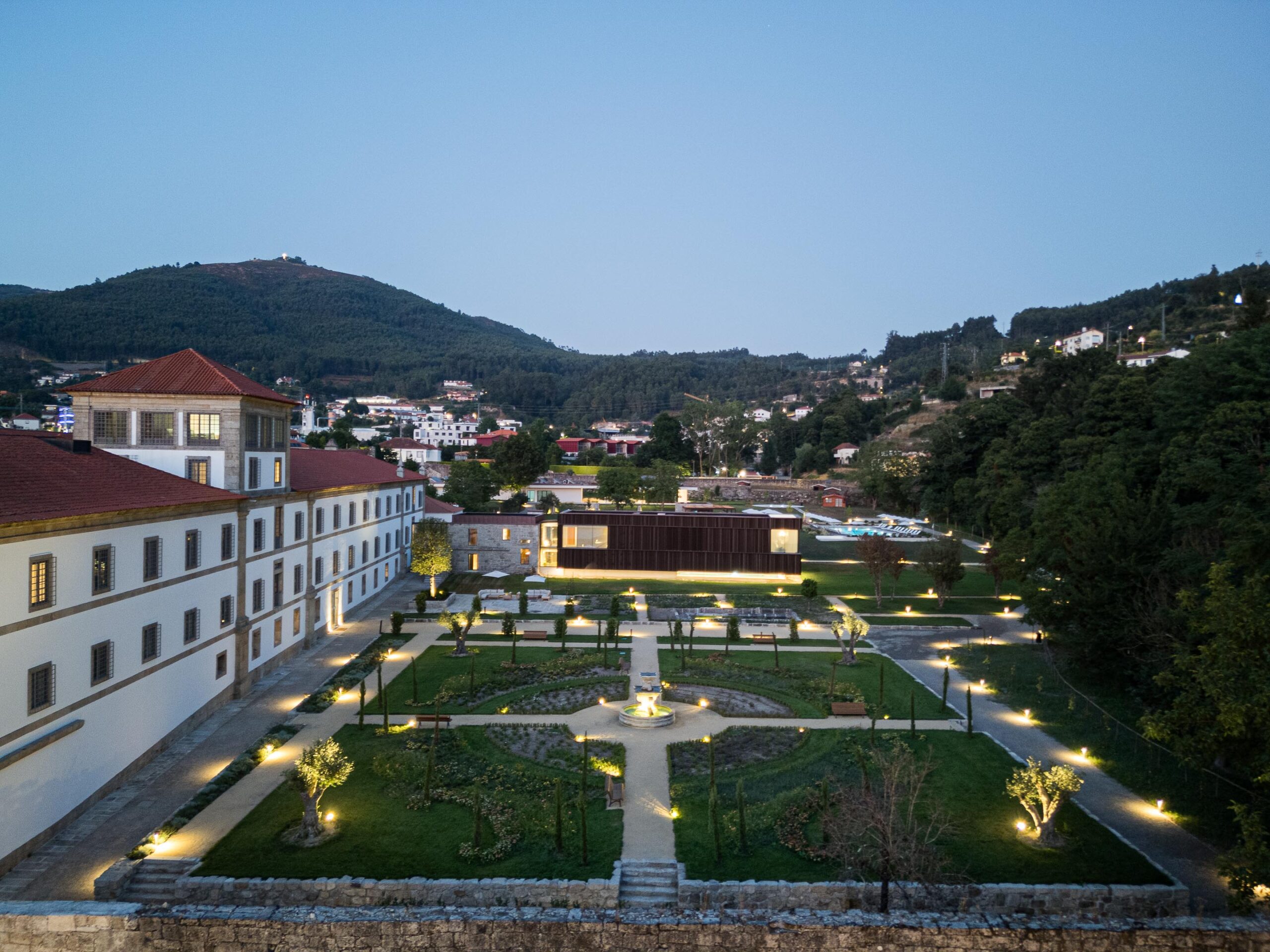 Vista noturna do complexo monástico e jardins, com iluminação exterior destacando os percursos e edifícios — MS COLLECTION AROUCA arquitectura MIMOOL ARQUITECTURA & INTERIORES fotografia Ivo Tavares