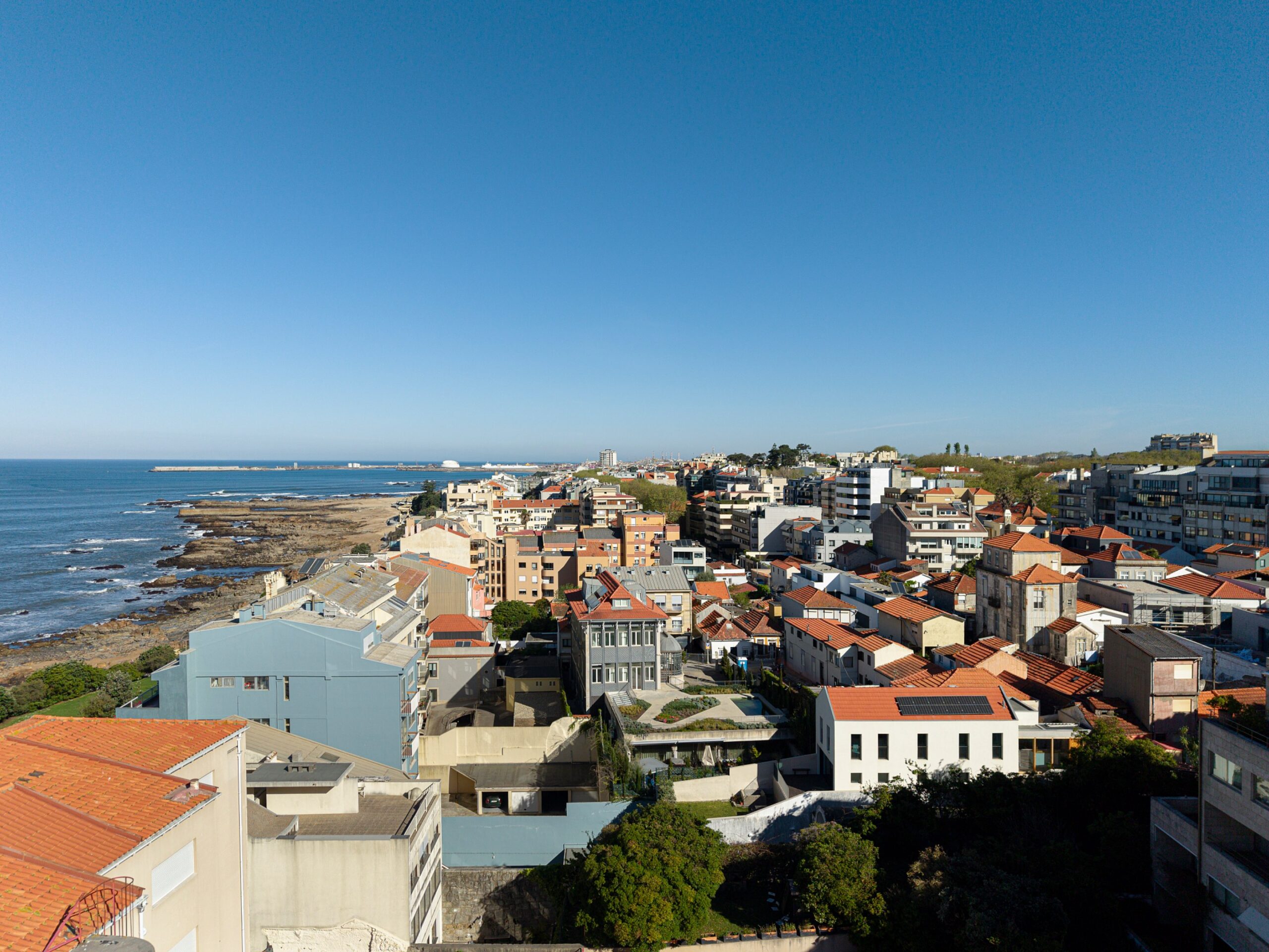 Vista aérea da cidade costeira com moradias de cobertura inclinada e edifícios modernos — Casa sem Rua