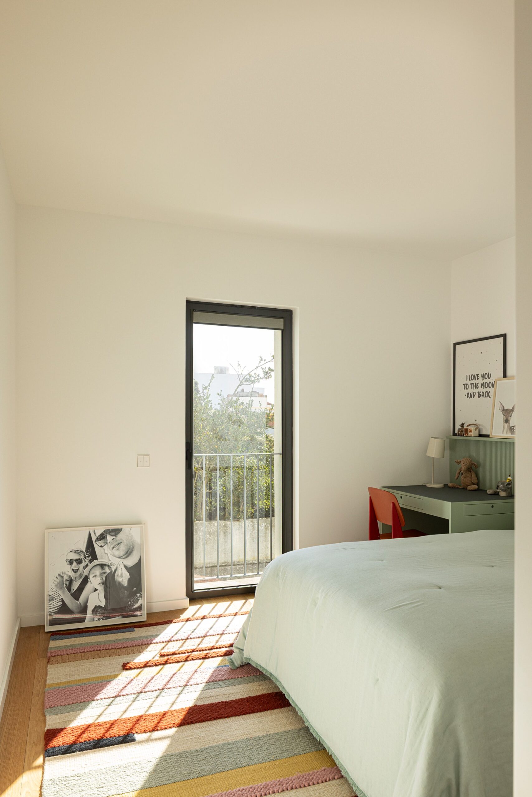 Quarto com pavimento em madeira de carvalho, tapete colorido e vão com varanda — Casa sem Rua