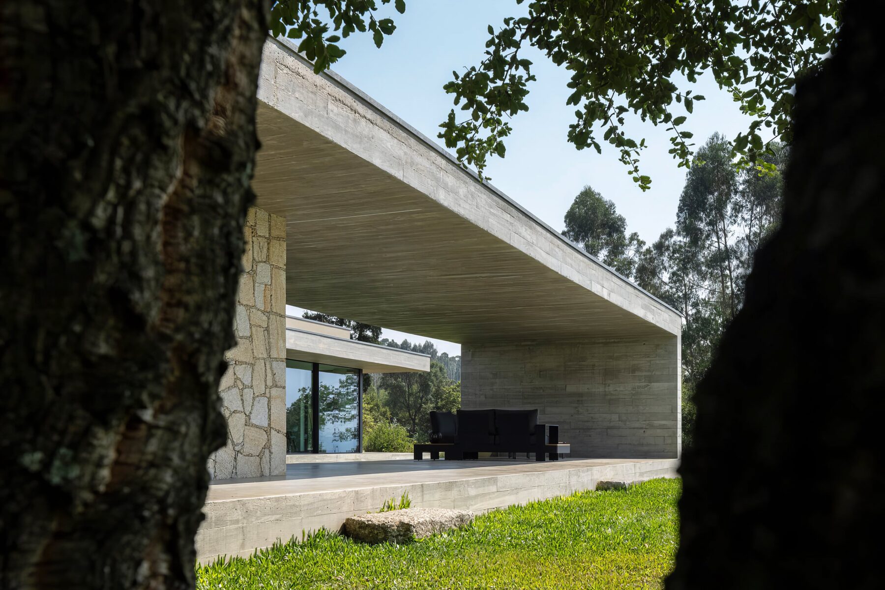 Alpendre exterior com pavimento em betão aparente, mobiliário de exterior e cobertura em betão moldado in situ — Quinta da Casa (Habitação QC)